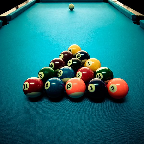 Juego de bolas de billar numeradas acomodadas en triángulo sobre el paño